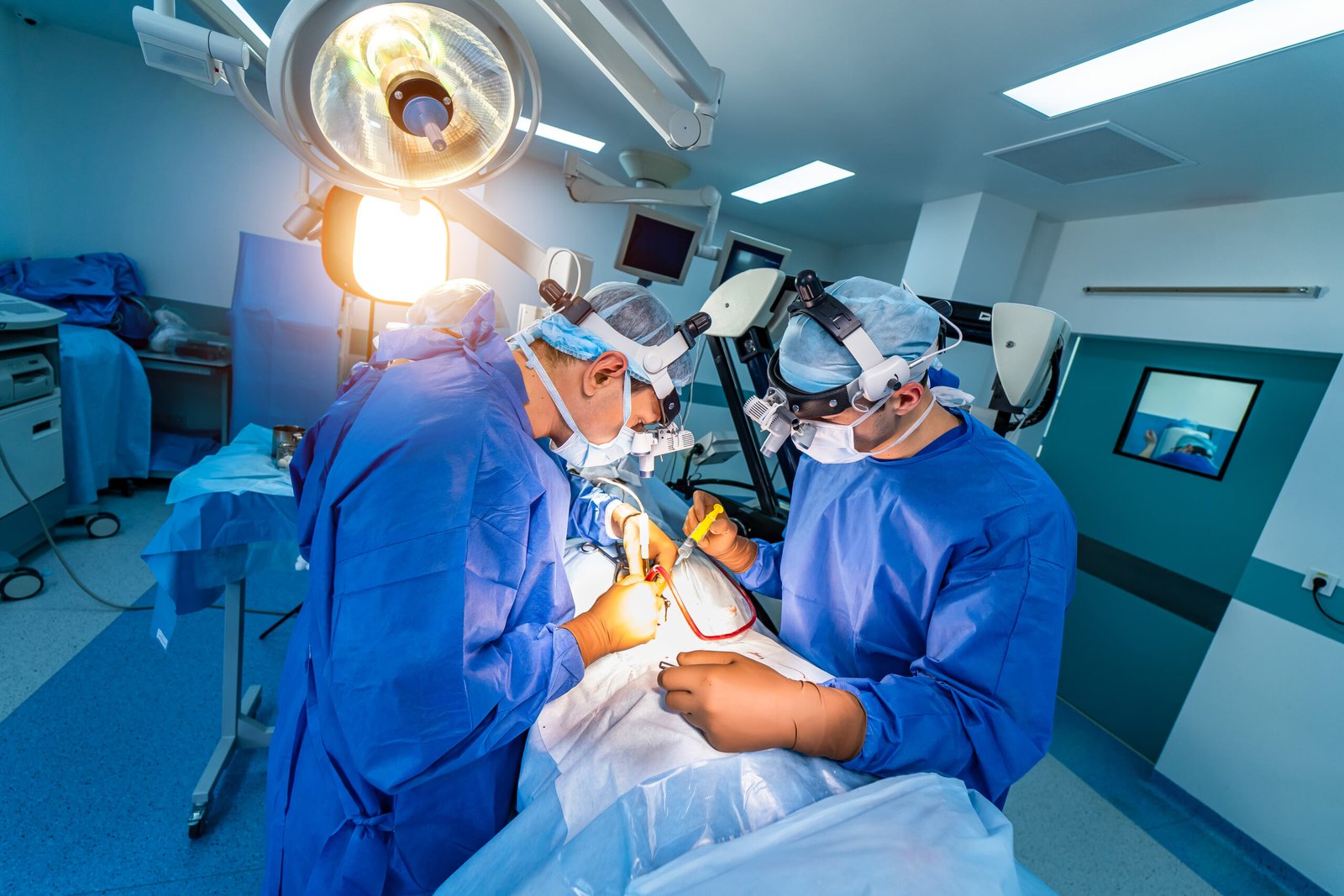Spinal surgery. Group of surgeons in operating room with surgery equipment. Doctor looking at screen. Modern medical background